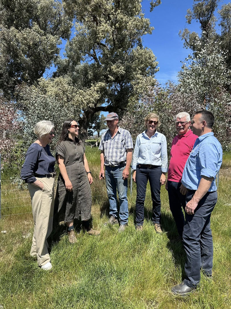 A group posing for a picture with forest as a background